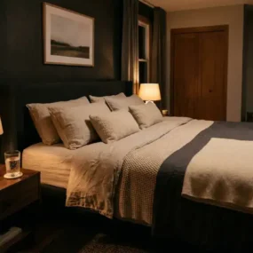 Cosy bedroom with warm lighting and book on nightstand representing a healthy night routine for better sleep