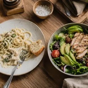 Plate of refined carbs next to a fresh energy-boosting salad, foods that cause fatigue